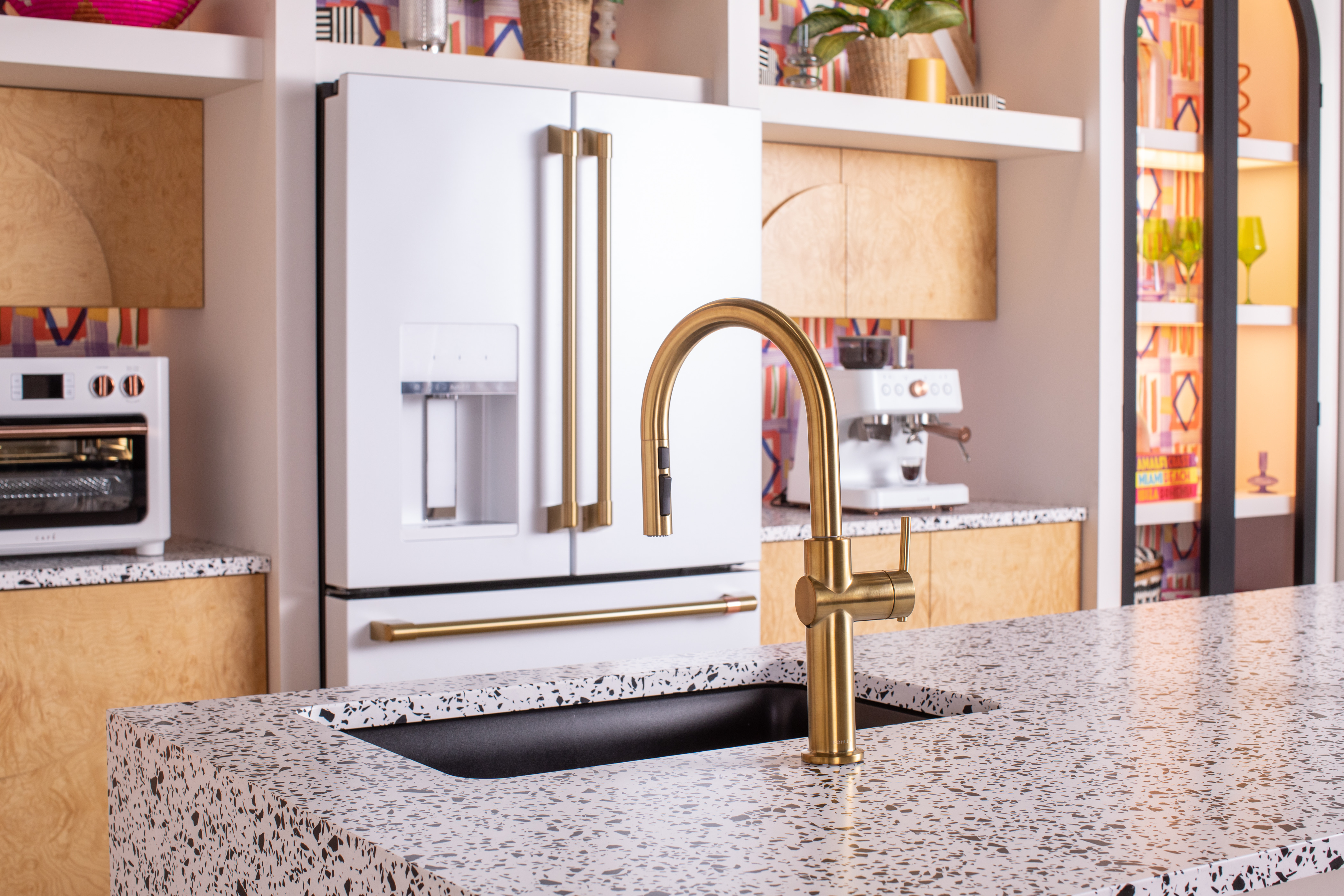 Cafe A Cafe matte white refrigerator with gold hardware matching a gold kitchen facet